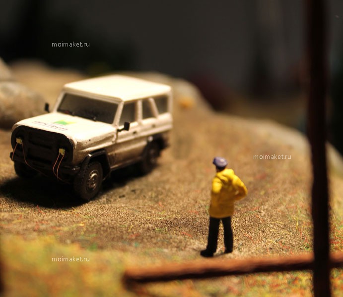машина и человек в желтом плаще на макете